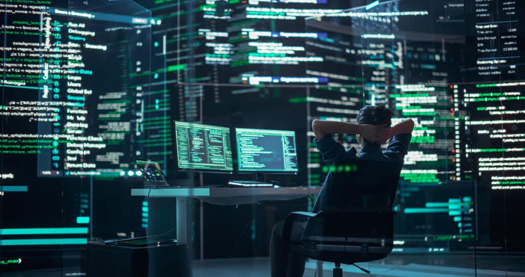 Professional Programmer Surrounded by Big Screens Showing Coding Language, Creating Software.